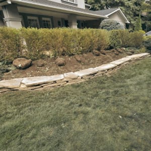 This project required careful attention to detail as the client requested the use of a specific flagstone that matched the existing elements throughout the backyard. Although the material was challenging to source, our team successfully incorporated it into a retaining wall designed to frame the garden bed. The result blends seamlessly with the surrounding landscape while adding both structure and visual appeal. Project 5 Retaining Wall Installation