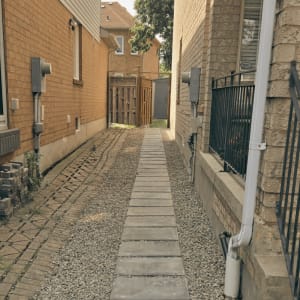 Persistent water accumulation in the backyard made proper drainage the main priority of this project. By regrading the area and installing a French drain, we successfully redirected excess water away from the property. A new walkway made from pre-cast concrete slabs was also added along the side of the house, improving both functionality and appearance. Project 18 Drainage and Grading Project
